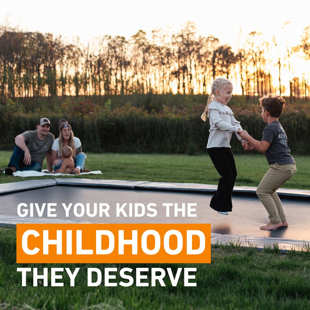 Kids jumping at sunset on an in-ground trampoline