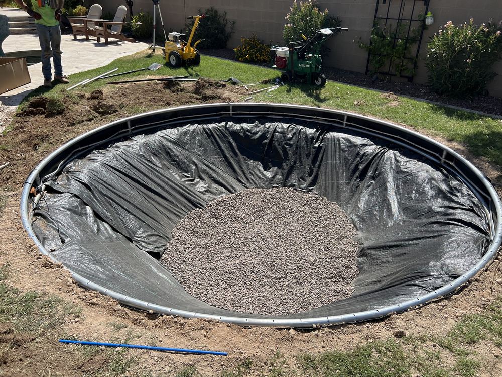 Weed barrier and gravel drainage bed in a round trampoline hole