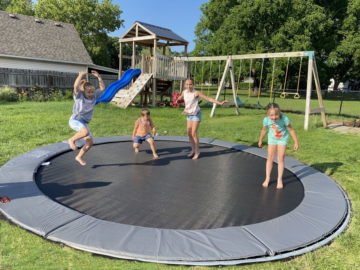 Kids jumping on an in-ground trampoline