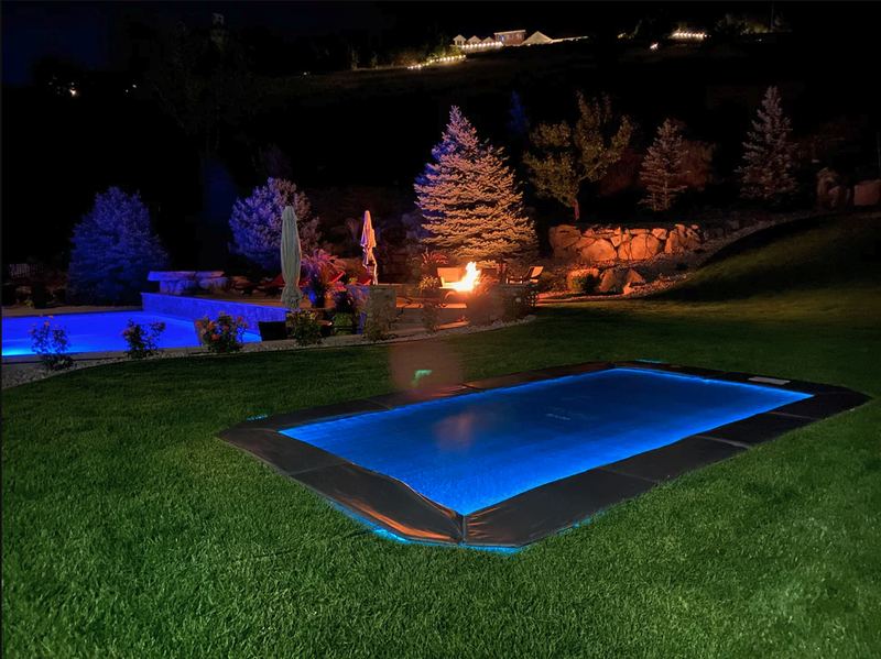 LED light kit glowing blue around an in-ground trampoline