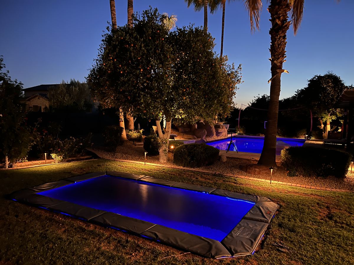 In-ground trampoline lit with LED lights at dusk