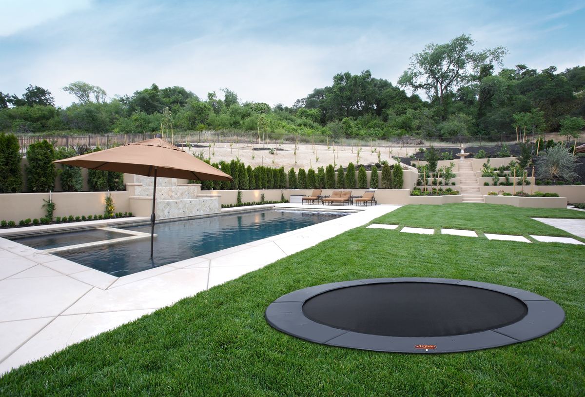 15 foot round in-ground trampoline in a modern backyard