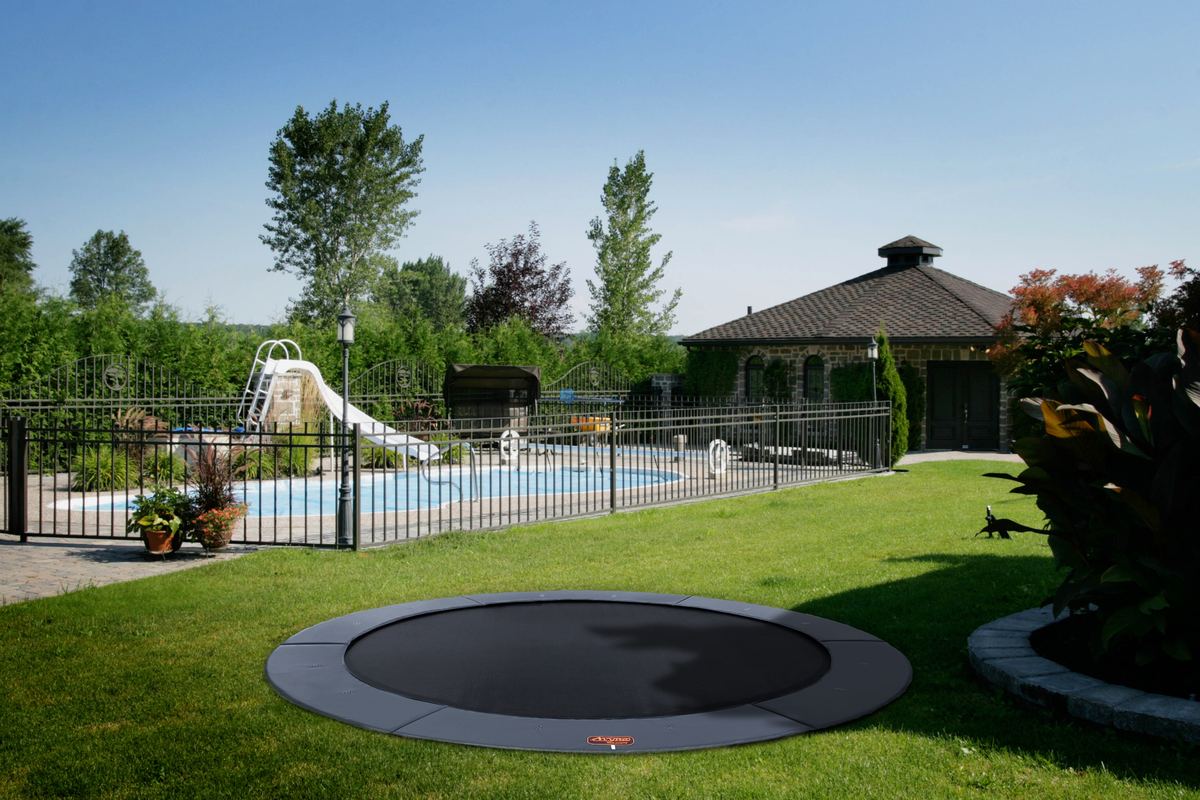 12 foot round Avyna Pro-Line in-ground trampoline beside a pool